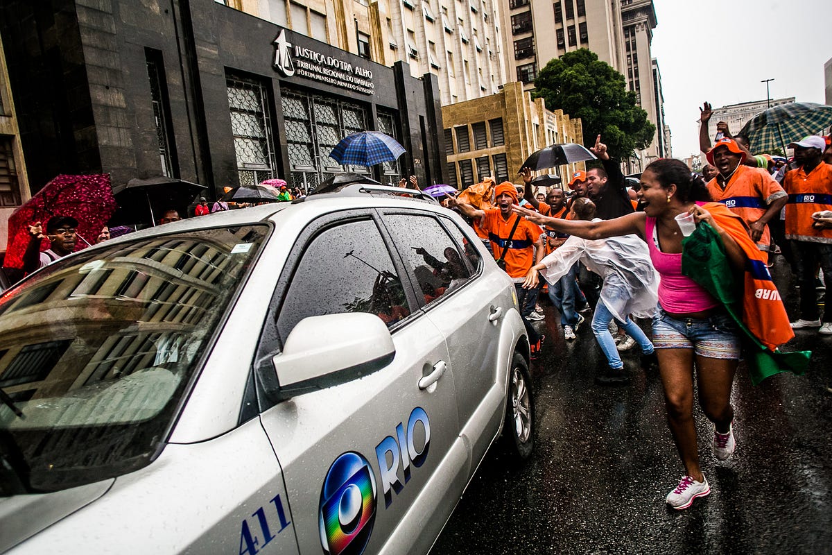 Carro da Rede Globo é expulso de forma pacífica do Tribunal de Justiça do Trabalho. A emissora foi impedida de entrar para acompanhar as negociações por ação dos Garis.