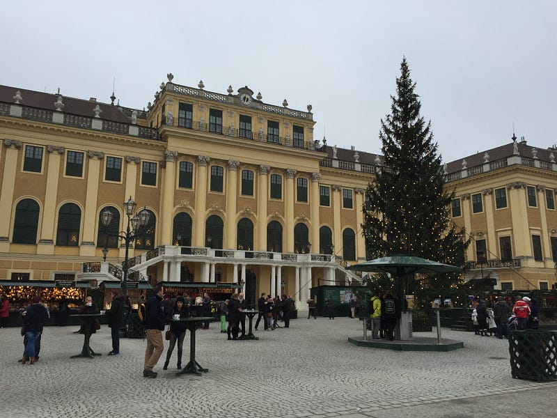 Schonbrunn Palace entrance. Christmas markets in front of the palace feeding hungry tourists with gluhwein, wursts, and waffles.